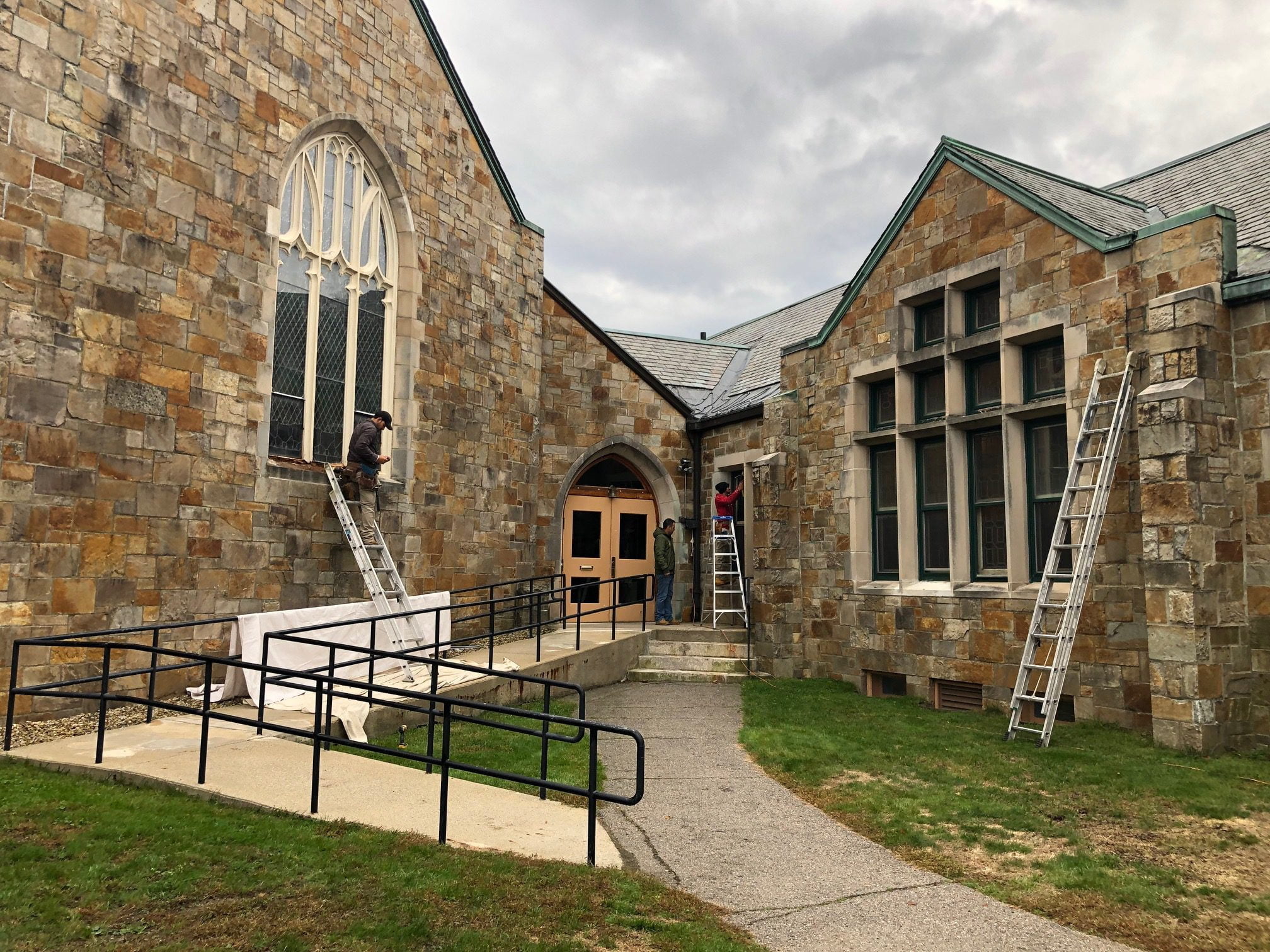 church windows with ladders undergoing repairs