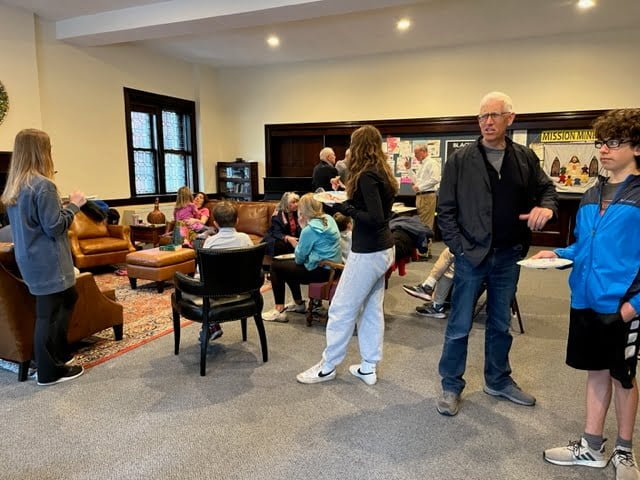 People eating pizza in church parlor after Family Promise Metrowest Walk to End Homelessness