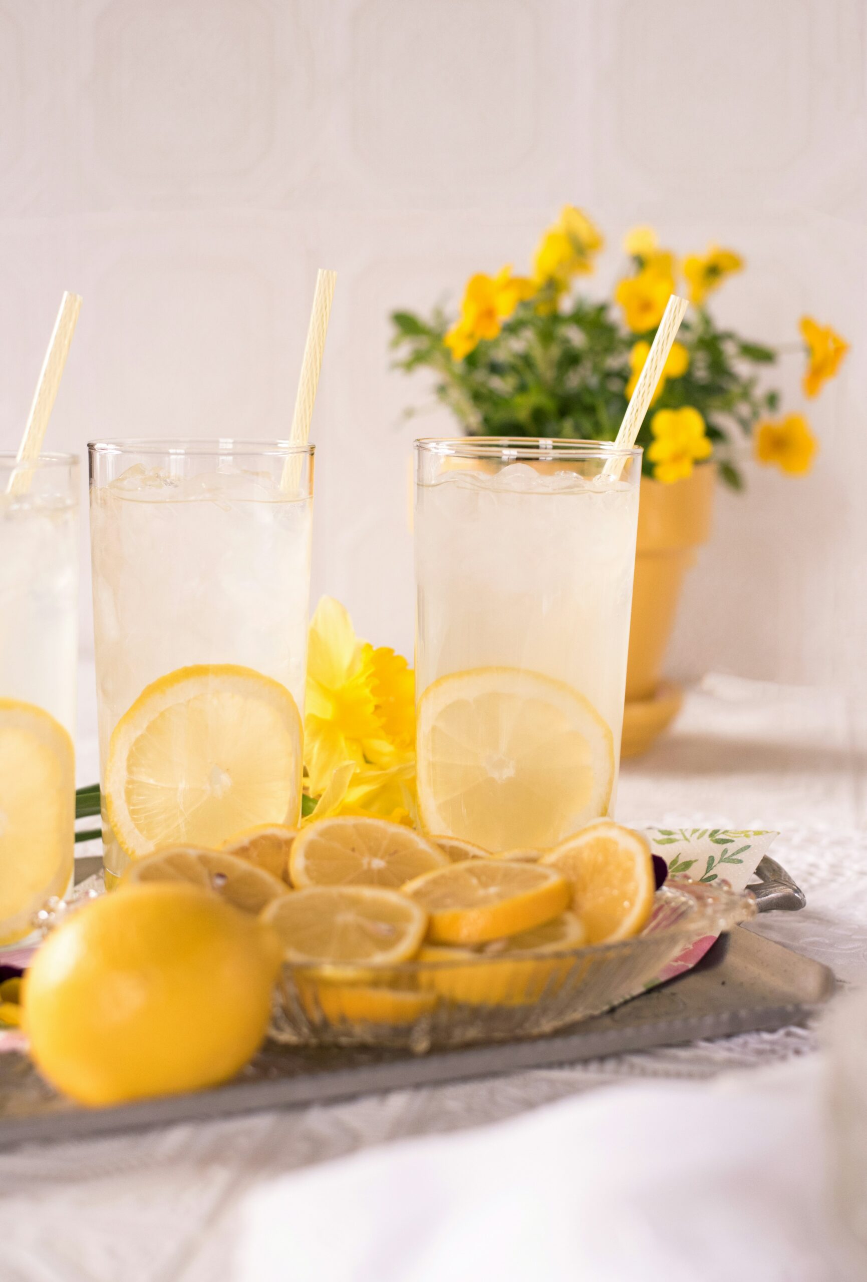 two glasses of lemonade on tray with lemons