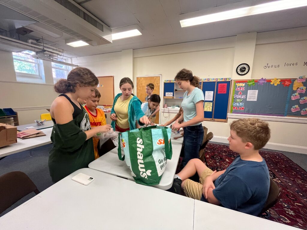 Young people making sandwiches and packing them in a bag