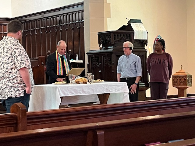 Communion ritual in sanctuary with minister and four helpers