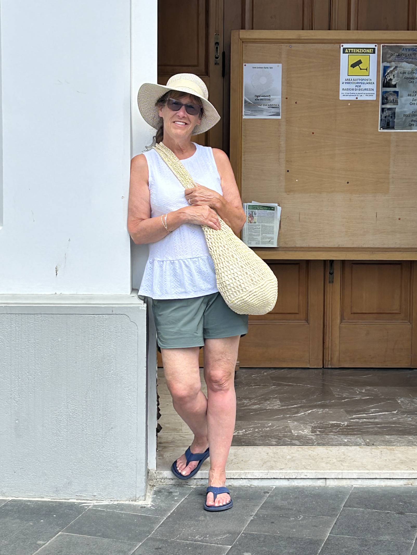 Director of Christian Ed Wendy Donnell leaning against a doorway in shorts and a blouse
