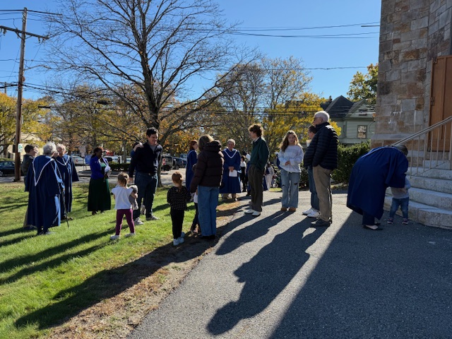 people in coats on church lawn