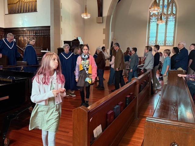 Adults and children taking communion in sanctuary