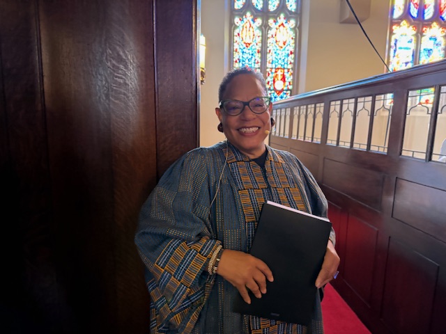 Female pastor smiling in church sanctuary