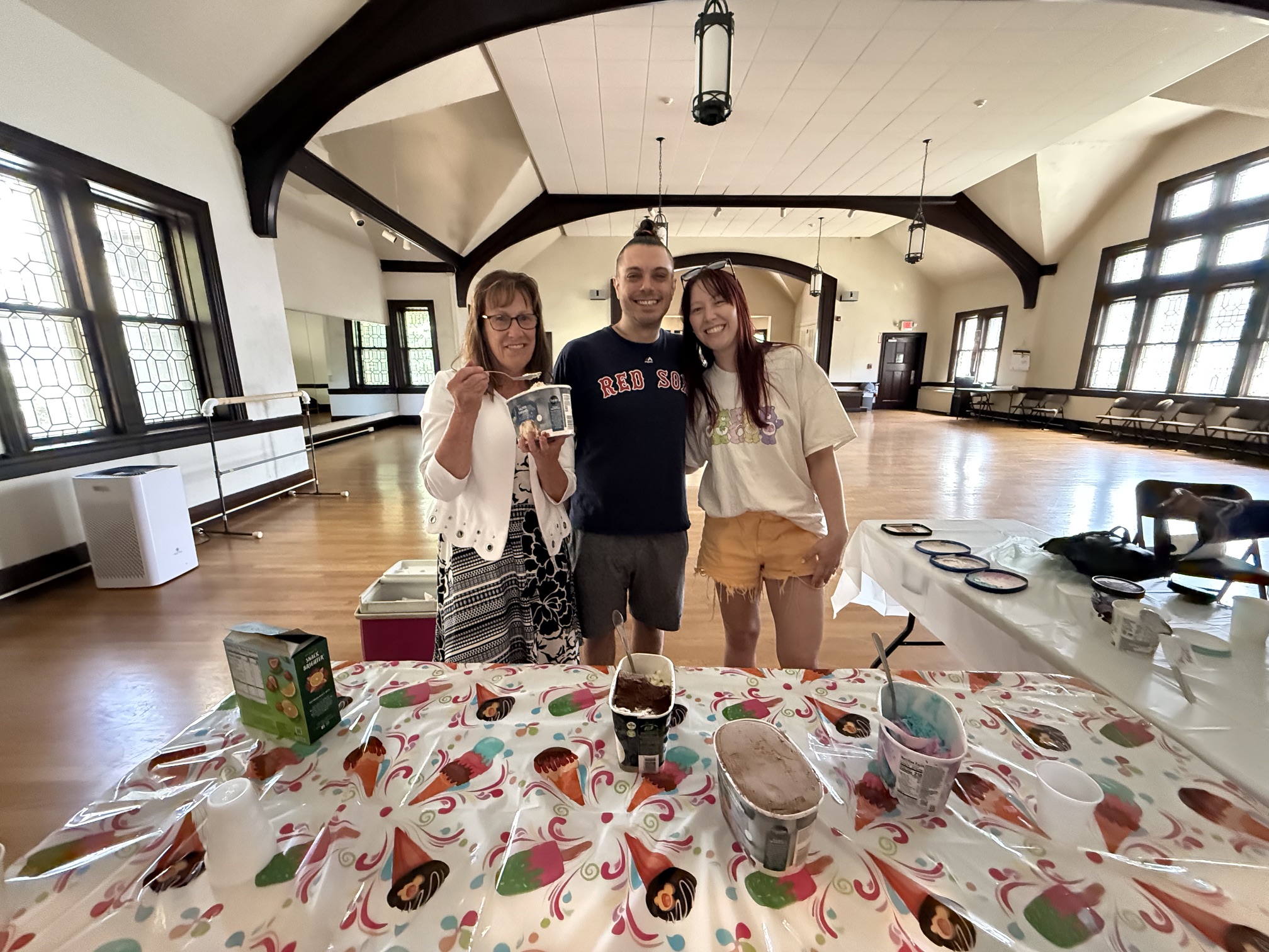 3 adults serving ice cream at a table