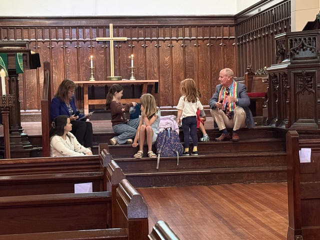 Children and adults in sanctuary with backpacks